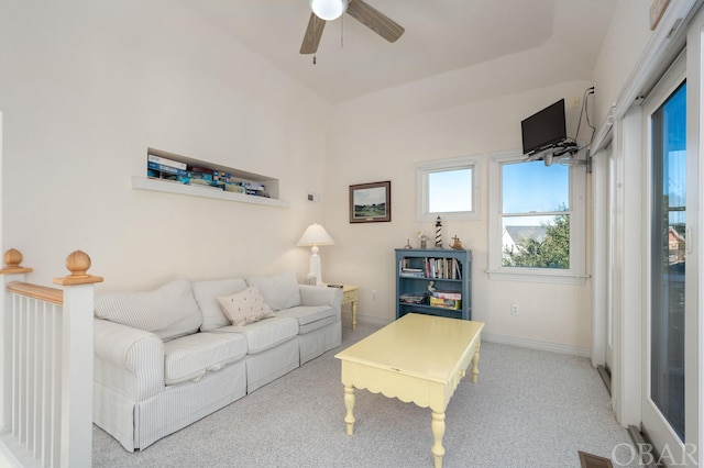 living area with light carpet, ceiling fan, and baseboards