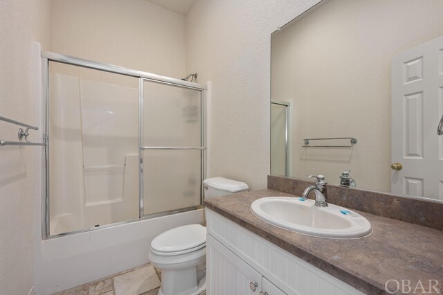 bathroom with toilet, enclosed tub / shower combo, and vanity