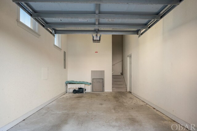 garage featuring electric panel and baseboards