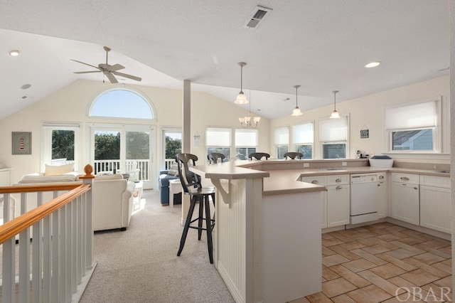 kitchen featuring visible vents, hanging light fixtures, open floor plan, white cabinetry, and white dishwasher