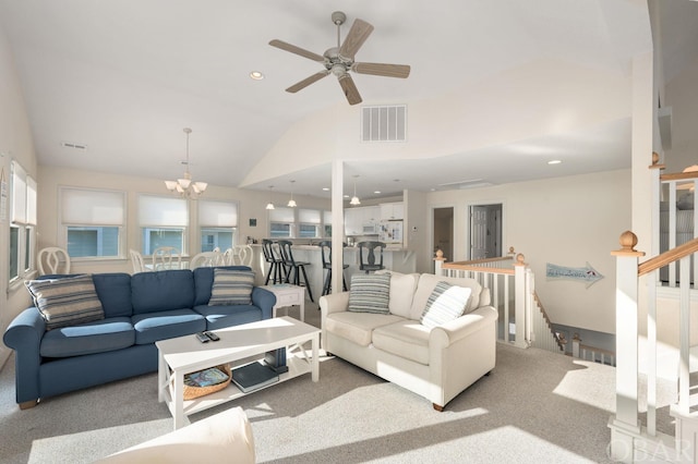 carpeted living area featuring recessed lighting, visible vents, stairs, vaulted ceiling, and ceiling fan with notable chandelier