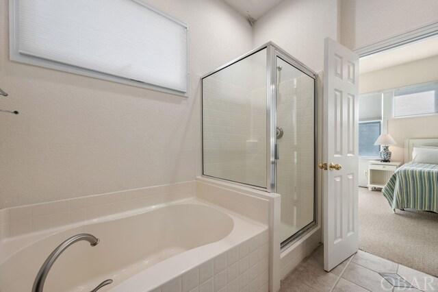 ensuite bathroom with tile patterned floors, a shower stall, a garden tub, and ensuite bathroom