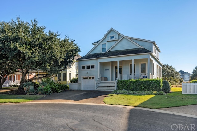 view of front of house featuring a garage, a front yard, covered porch, and driveway