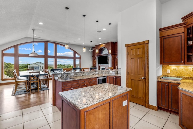 670 Hunt Club Dr Lot 194, Corolla, NC 27927 - kitchen with lofted ceiling, a peninsula, a center island, light tile patterned flooring, and light stone counters