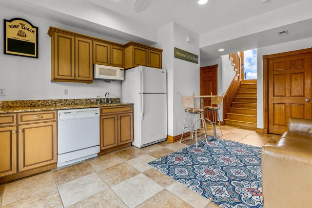 670 Hunt Club Dr Lot 194, Corolla, NC 27927 - kitchen with white appliances, dark stone countertops, recessed lighting, brown cabinets, and a sink