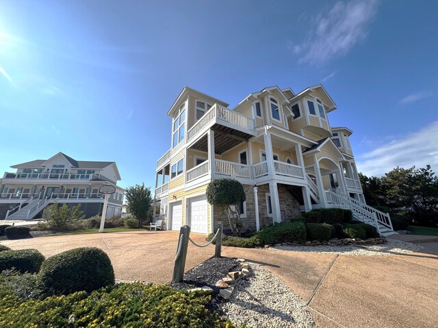 670 Hunt Club Dr Lot 194, Corolla, NC 27927 - beach home with stone siding, an attached garage, stairs, and a balcony