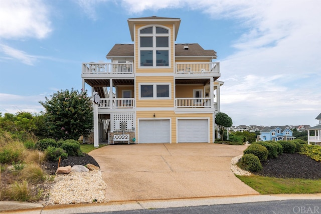 raised beach house featuring driveway and an attached garage