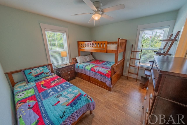 bedroom with light wood-style floors, baseboards, and a ceiling fan