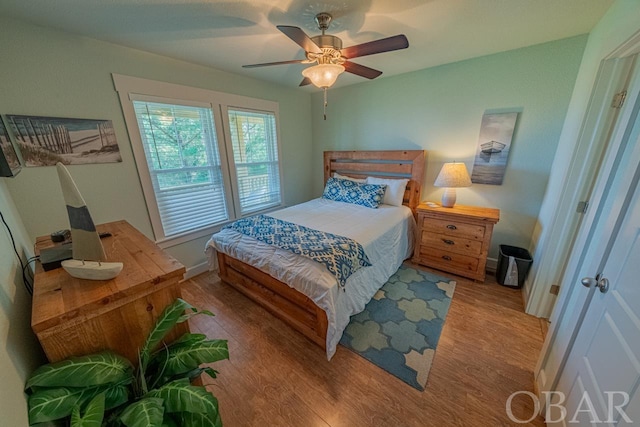 bedroom featuring light wood finished floors, ceiling fan, and baseboards