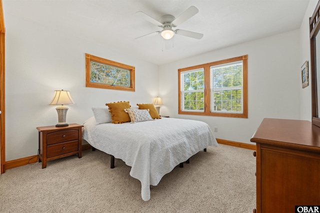 bedroom with baseboards, a ceiling fan, and light colored carpet