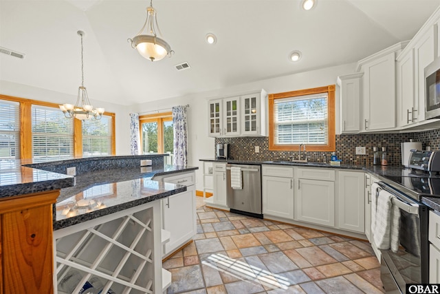 kitchen featuring stainless steel appliances, hanging light fixtures, visible vents, and white cabinetry