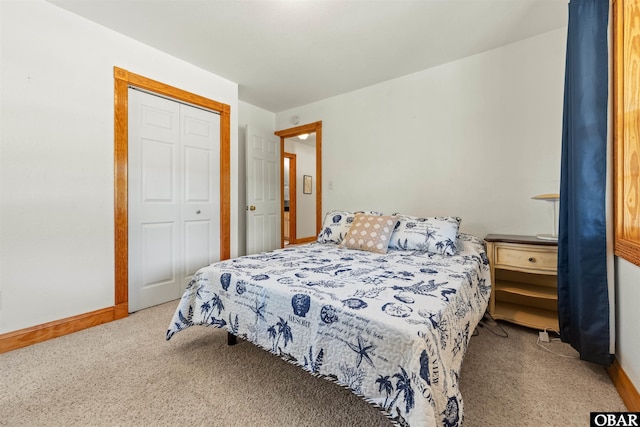 carpeted bedroom featuring baseboards and a closet