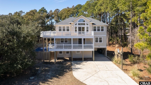 view of front of property with driveway, a balcony, and a carport