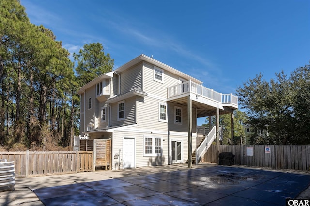 rear view of property featuring stairway and fence