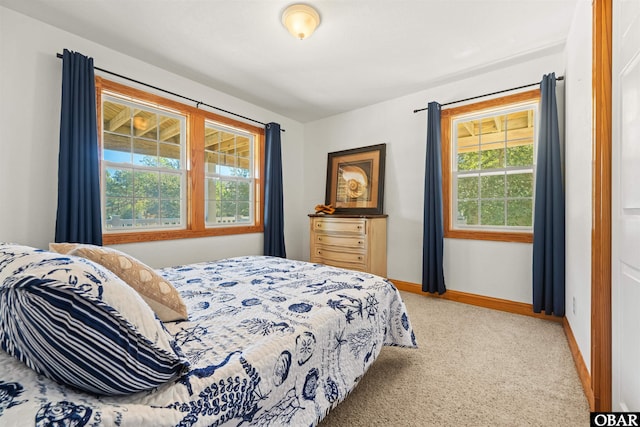 bedroom with light carpet and baseboards