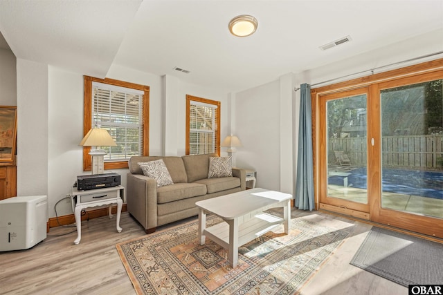 living room featuring baseboards, visible vents, and light wood-style floors