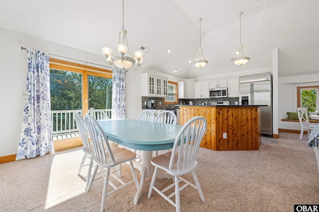 dining room with a chandelier, baseboards, visible vents, and light colored carpet