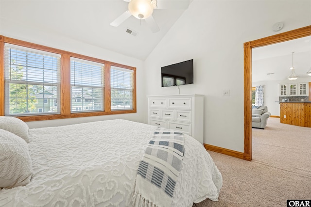 bedroom featuring lofted ceiling, carpet floors, multiple windows, and baseboards