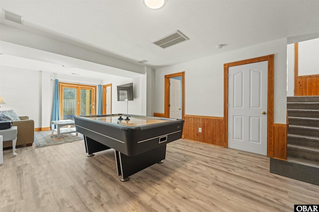 playroom with light wood-style flooring, visible vents, and wainscoting