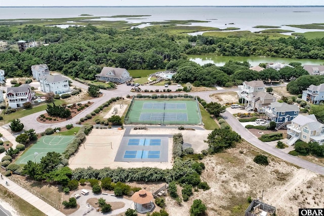 birds eye view of property featuring a water view and a wooded view