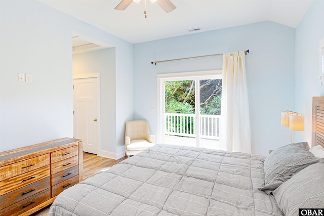 bedroom with wood finished floors, a ceiling fan, visible vents, vaulted ceiling, and access to exterior