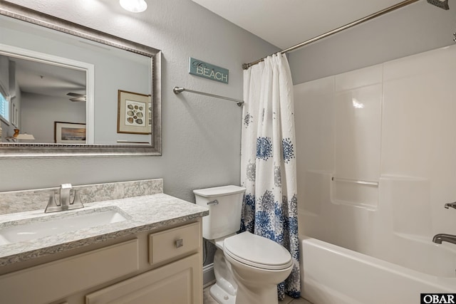 bathroom with toilet, a textured wall, shower / bath combo with shower curtain, and vanity