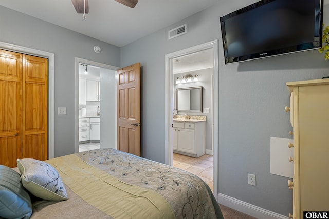 bedroom with baseboards, visible vents, and connected bathroom