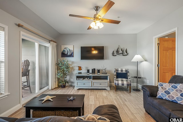 living room with light wood-style flooring, baseboards, and ceiling fan