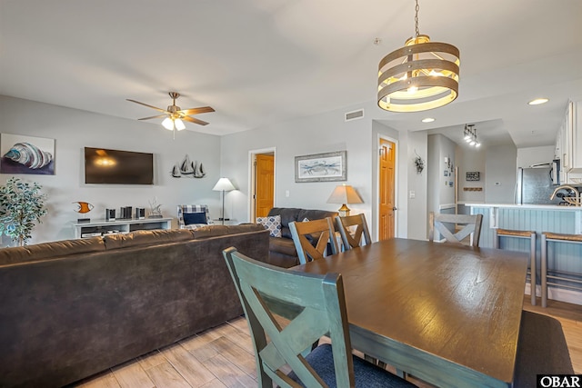 dining space featuring a ceiling fan, visible vents, and light wood-style floors