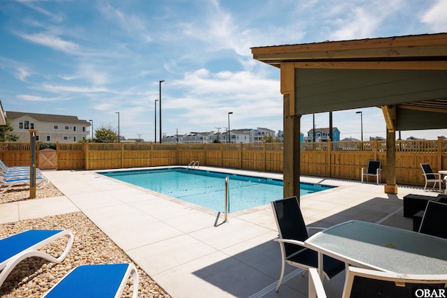 community pool featuring a patio and fence