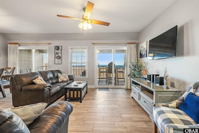 living area with wood tiled floor, ceiling fan, and baseboards