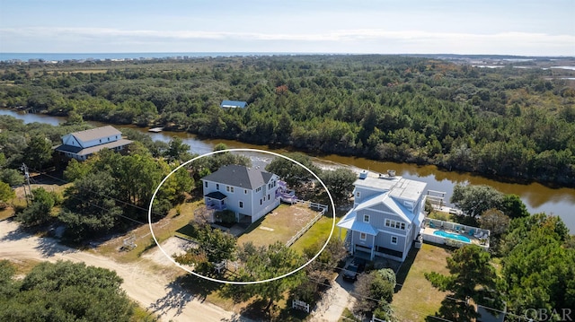 drone / aerial view featuring a water view and a view of trees