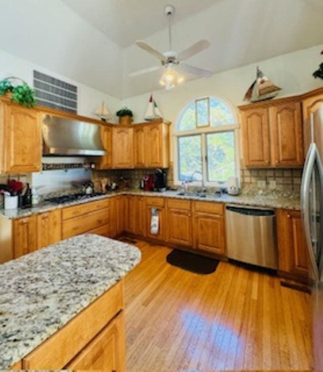 290 Hillcrest Dr Lot 22, Southern Shores, NC 27949 - kitchen with light wood-style floors, tasteful backsplash, wall chimney range hood, a sink, and stainless steel appliances