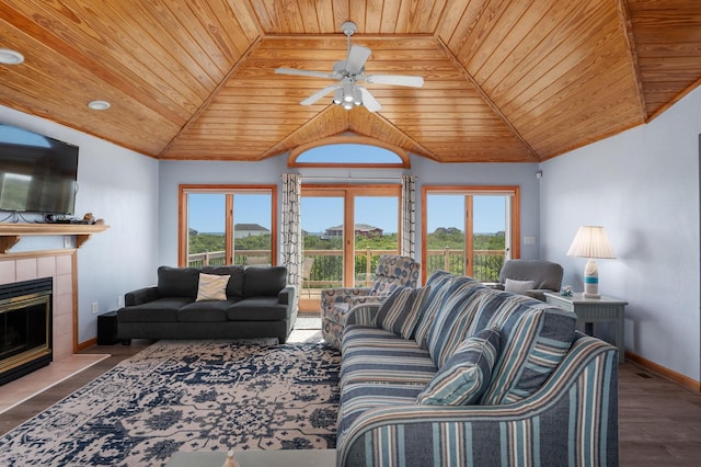 living room featuring lofted ceiling, a tiled fireplace, wood finished floors, and baseboards