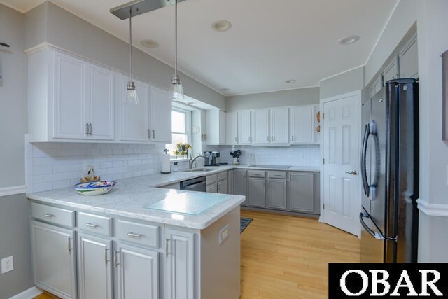 4025 Ivy Ln Lot 11, Kitty Hawk, NC 27949 - kitchen with decorative backsplash, light wood-type flooring, dishwasher, freestanding refrigerator, and a peninsula