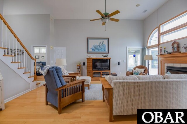 4025 Ivy Ln Lot 11, Kitty Hawk, NC 27949 - living area with high vaulted ceiling, a tiled fireplace, light wood-style flooring, a ceiling fan, and stairway