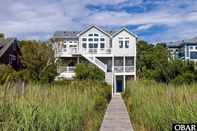 rear view of property with a sunroom and stairway