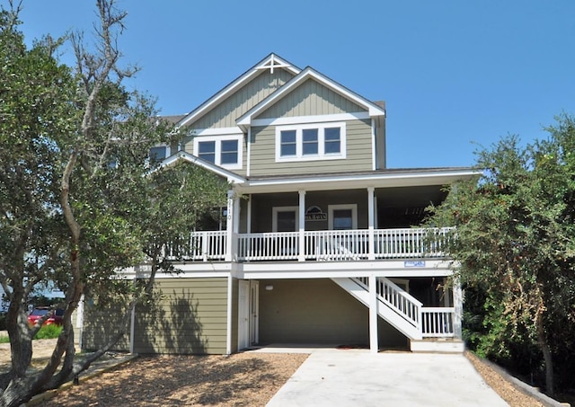 view of front facade featuring a porch, concrete driveway, a carport, and board and batten siding