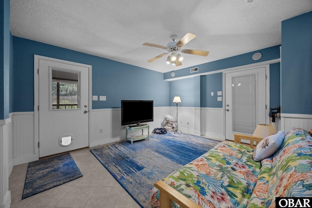 305 W Fourth St Lot 7, Kill Devil Hills, NC 27948 - living room featuring a wainscoted wall, a textured ceiling, tile patterned floors, and a ceiling fan