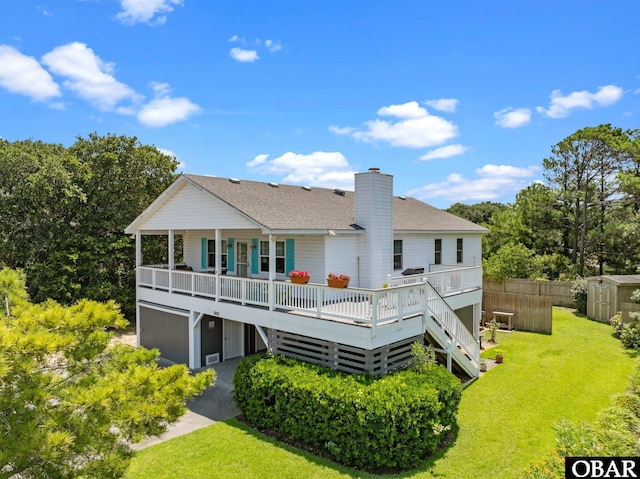 305 W Fourth St Lot 7, Kill Devil Hills, NC 27948 - back of house featuring a storage shed, a shingled roof, a chimney, and a deck
