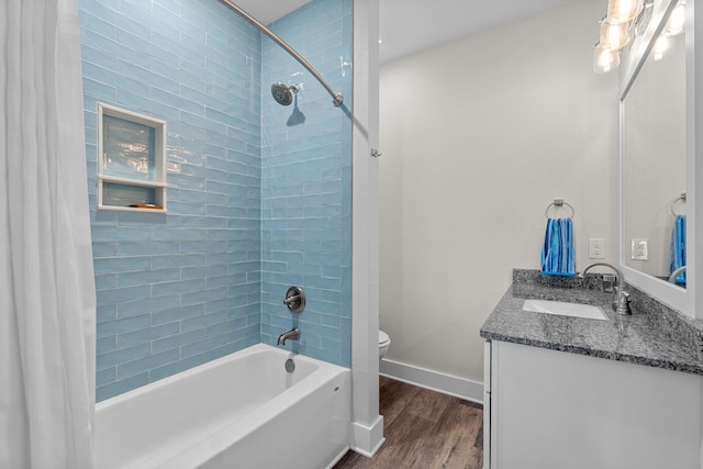 full bathroom featuring toilet, shower / bath combo, vanity, wood finished floors, and baseboards