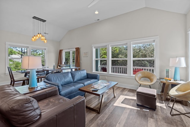 living room with vaulted ceiling, baseboards, wood finished floors, and a notable chandelier