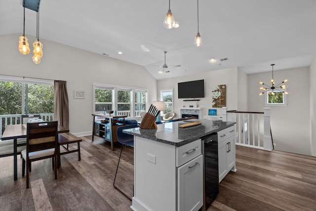 kitchen featuring vaulted ceiling, wine cooler, a kitchen island, and dark wood finished floors