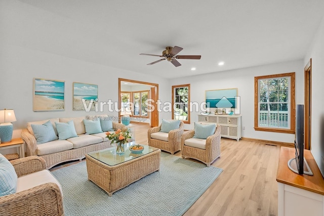 living room with recessed lighting, plenty of natural light, a ceiling fan, and light wood-style floors