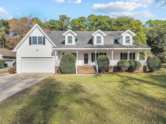 new england style home featuring an attached garage, driveway, a porch, and a front yard