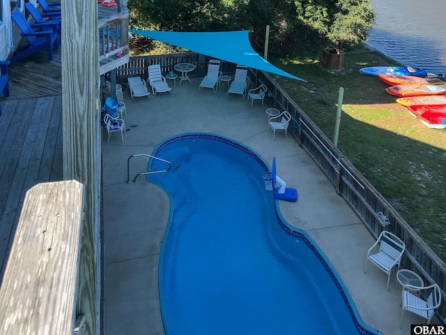 view of pool featuring a fenced in pool, a deck with water view, and a yard