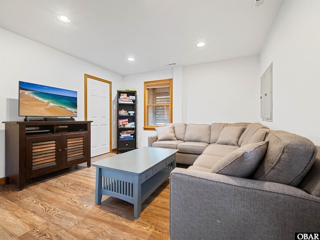 living room with light wood finished floors, electric panel, visible vents, and recessed lighting