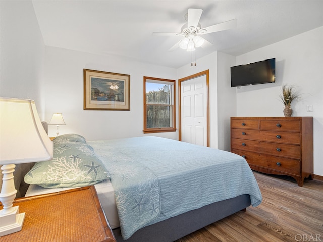 bedroom featuring wood finished floors, a ceiling fan, and baseboards