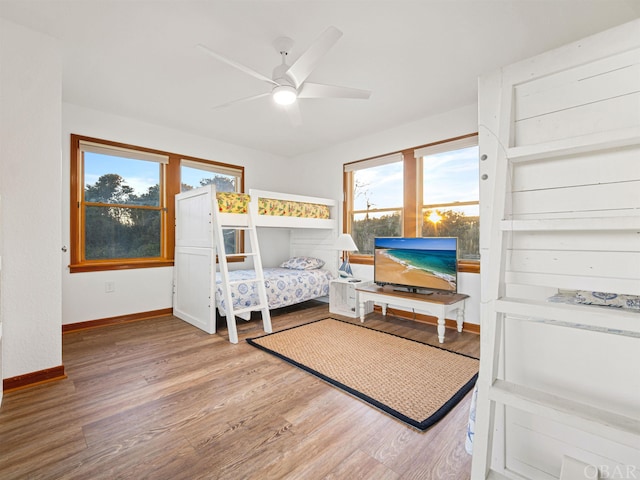 bedroom with ceiling fan, baseboards, and wood finished floors