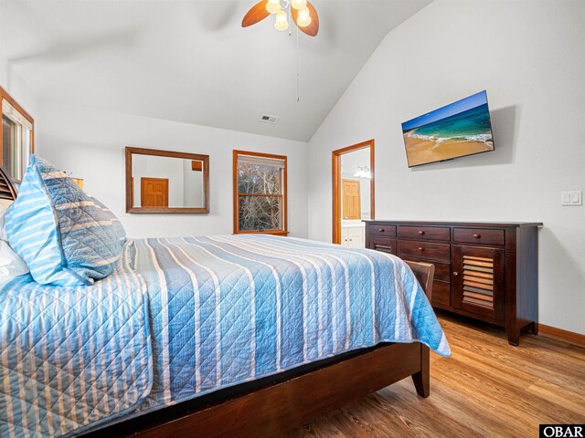 bedroom featuring visible vents, connected bathroom, lofted ceiling, ceiling fan, and light wood-type flooring